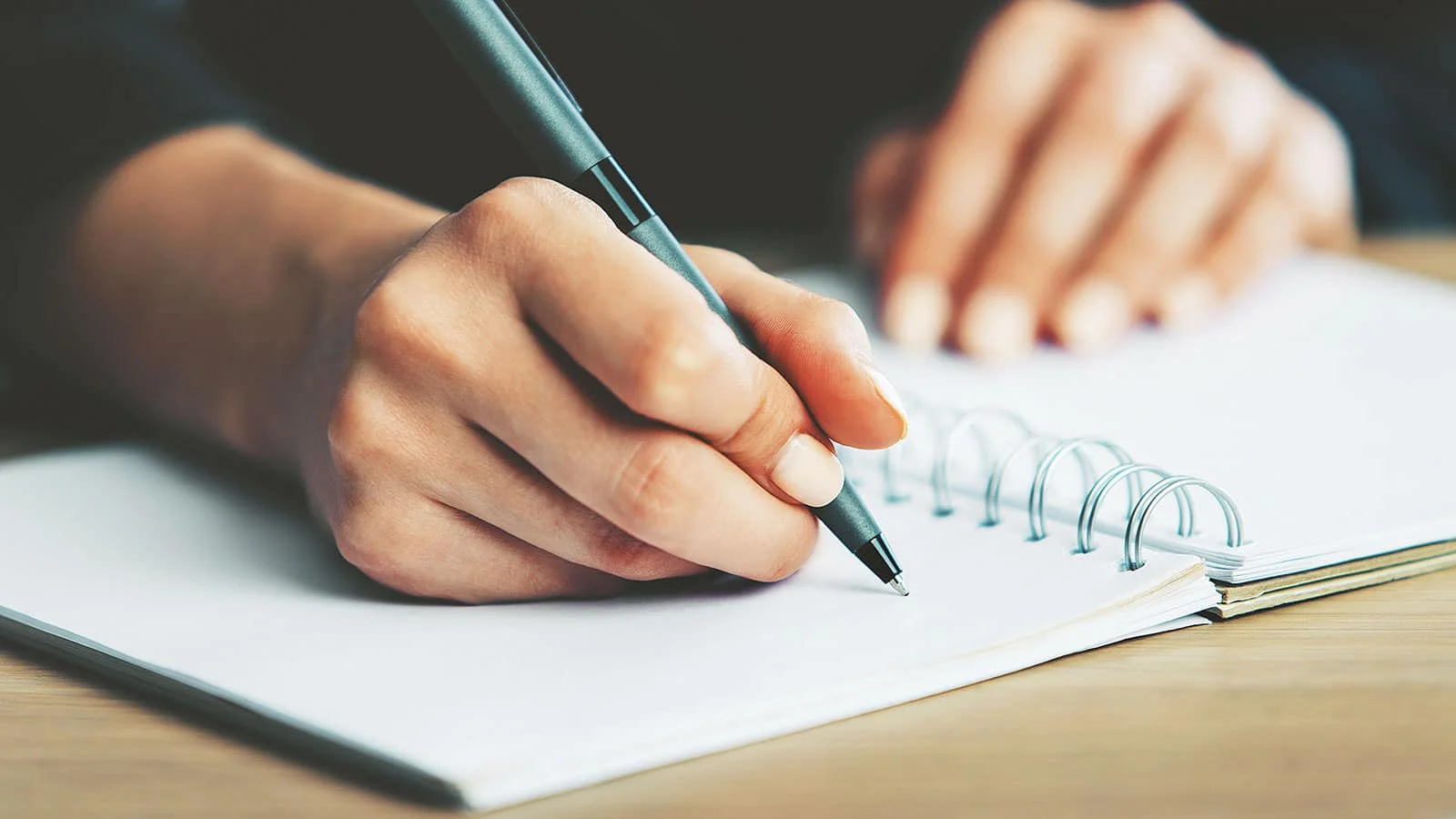 Una mano che scrive su un quaderno